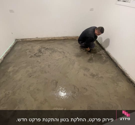 אדם משפץ רצפה עם בטון בחדר ריק